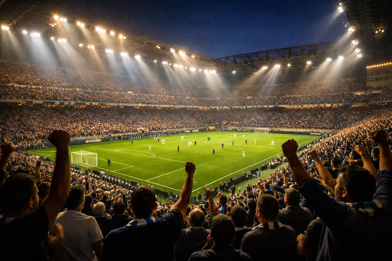 Tifosi allo stadio di calcio che esultano durante una partita serale sotto i riflettori