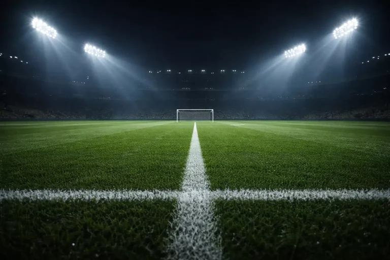 Campo da calcio illuminato di notte con atmosfera di grande partita europea sotto i riflettori